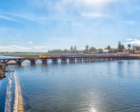 CAPE TOWN, SOUTH AFRICA, AUGUST 14, 2018: The lagoon in the Diep River and historic wooden bridge in Milnerton. Vehicles are visible